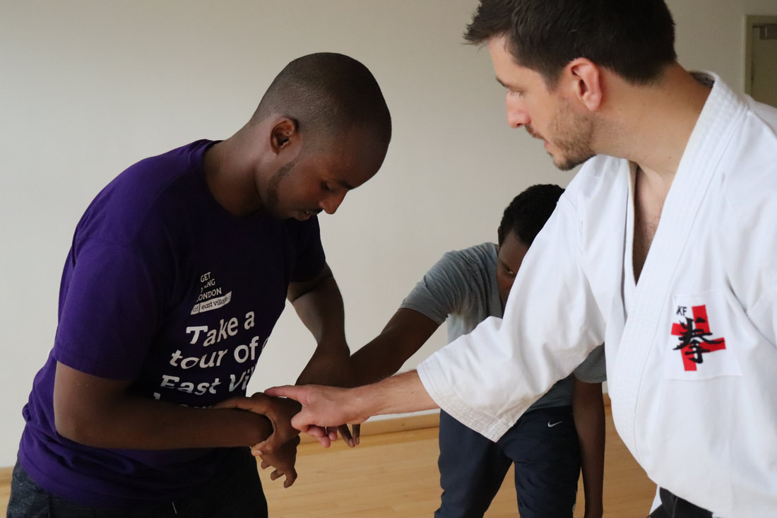 Two students learning one of Shorinji kempo's self-defence techniques